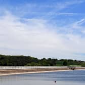 2019 image of fishermen sitting on their boat on the water in Blithfield reservoir near Rugeley, Staffordshire.