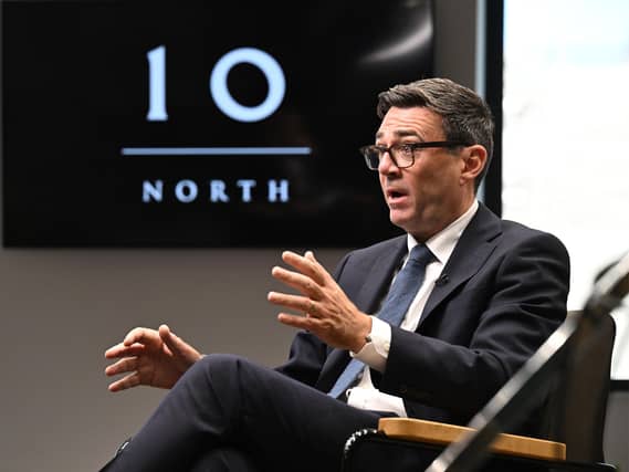 Andy Burnham talks in front of a TV screen with a logo for Number 10 North