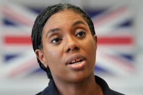 Headshot of Kemi Badenoch speaking, with a British flag in the background