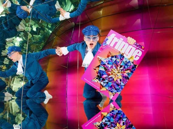 A performer holds an Edinburgh Fringe festival programme