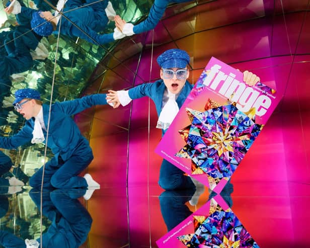 A performer holds an Edinburgh Fringe festival programme
