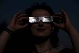 Planetarium astronomer Dr Carys Herbert demonstrates wearing Celestron solar eclipse glasses