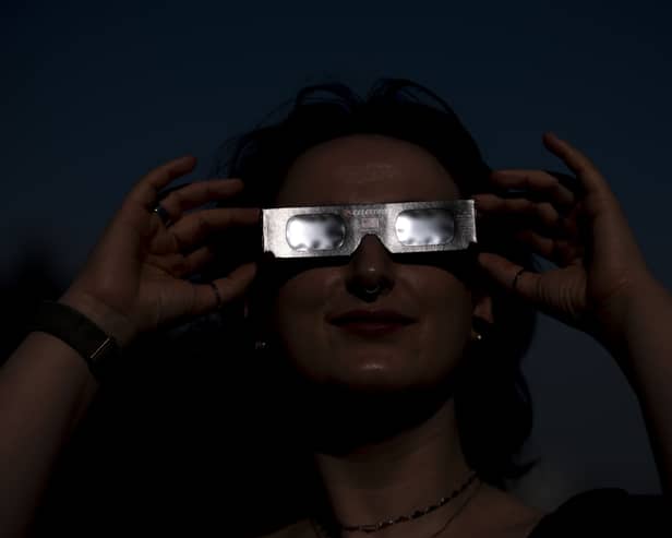 Planetarium astronomer Dr Carys Herbert demonstrates wearing Celestron solar eclipse glasses