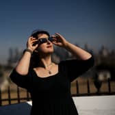 Planetarium astronomer Dr Carys Herbert demonstrates wearing Celestron solar eclipse glasses