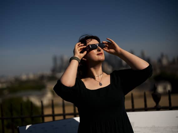 Planetarium astronomer Dr Carys Herbert demonstrates wearing Celestron solar eclipse glasses