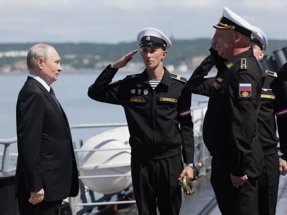 Russian President Vladimir Putin, left, visits a missile cruiser of the Pacific Fleet to watch a military exercise on Sakhalin Island, Russia Russian President Vladimir Putin, left, visits a missile cruiser of the Pacific Fleet to watch a military exercise on Sakhalin Island, Russia