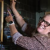 Grace McLaughlin smiling while signing her name on a board