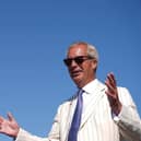 Nigel Farage wearing sunglasses with his hands held apart
