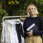 Ciara Tinney smiling, standing next to a rack of clothing