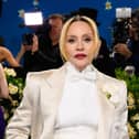 Madonna wearing a white suit and bow tie