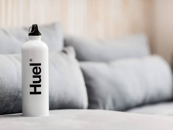 A Huel bottle with a sofa in the background