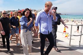 Duke and Duchess of Sussex walking along a beach