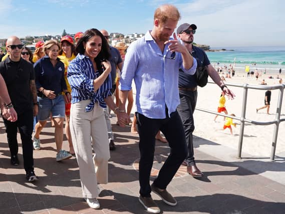Duke and Duchess of Sussex walking along a beach