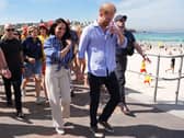 Duke and Duchess of Sussex walking along a beach