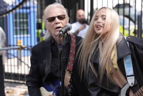 Brian Hyland and Ashleigh Harley playing guitars and singing outside Downing Street.