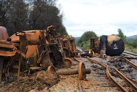 Burned out fuel wagons on a damaged railway line