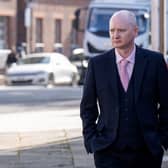 Graeme Dott walking outside, wearing a suit and tie