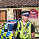 A police officer stands guard at Johnsons of Old Hurst