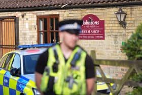 A police officer stands guard at Johnsons of Old Hurst