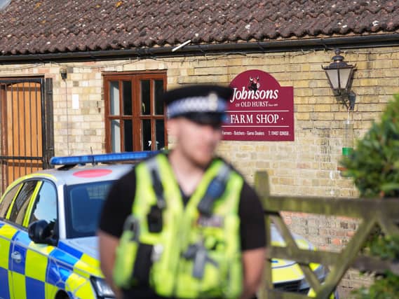 A police officer stands guard at Johnsons of Old Hurst