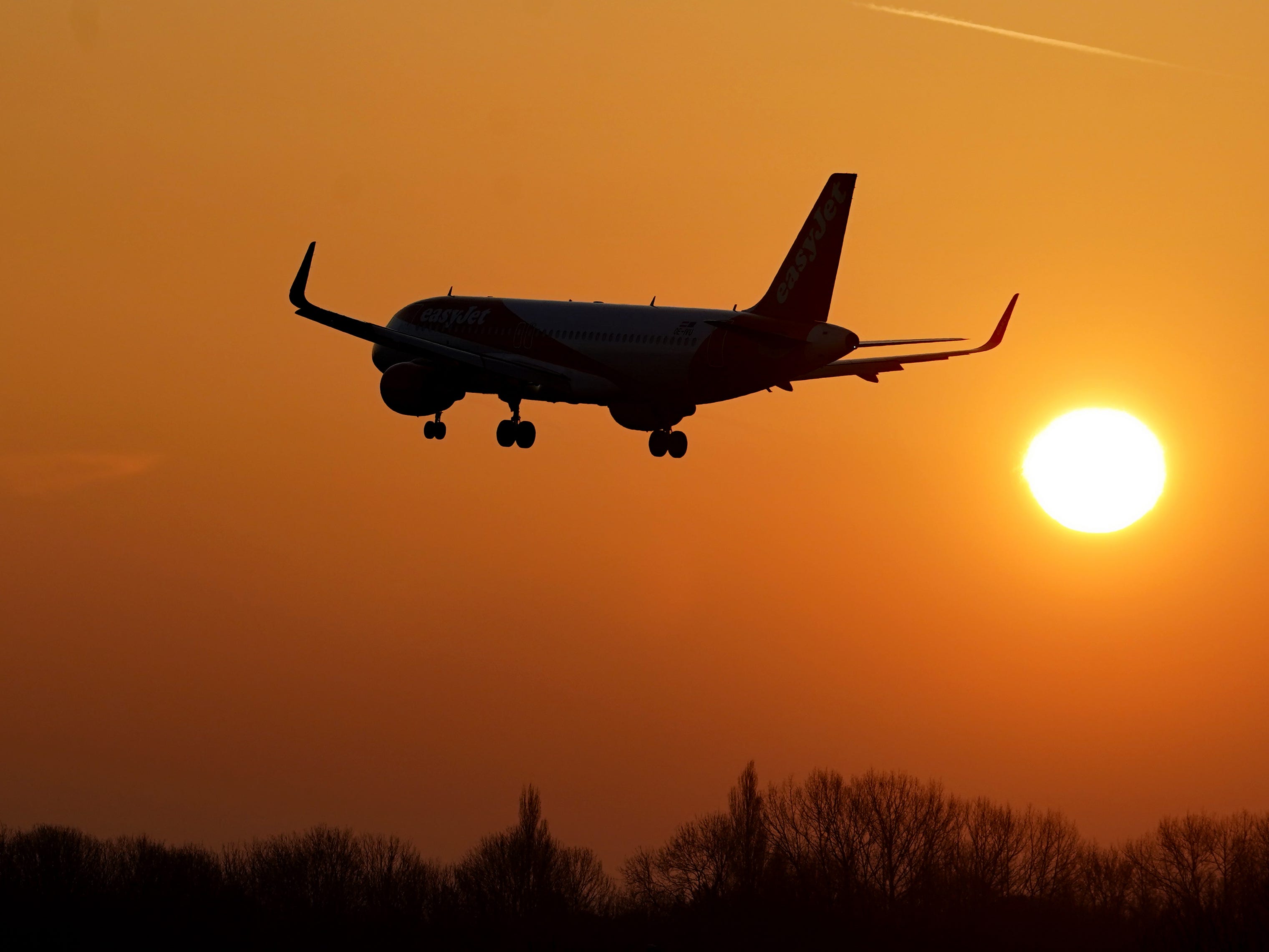 A flight takes off in the hazy morning sunshine
