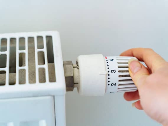 A hand turning a radiator dial