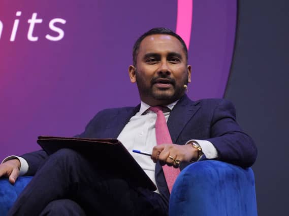Amol Rajan speaking while seated in an armchair on a stage