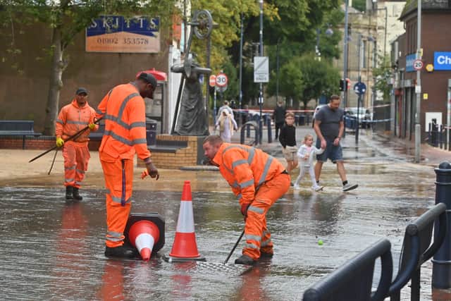 Burst water pipe in Bilston town centre, causing chaos for traders and shoppers. Lifting man hole covers for water to flow into.