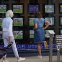 People looking at advertisements in an estate agents window
