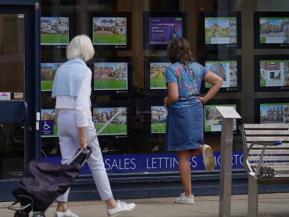People looking at advertisements in an estate agents window