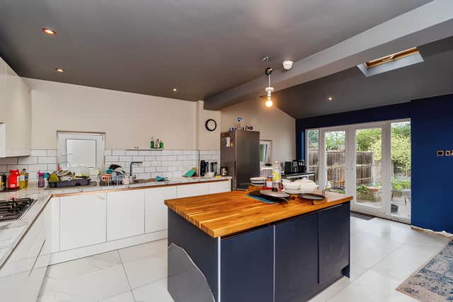 A newly installed kitchen with island sits within the bright rear extension, creating a sociable space for everyday living