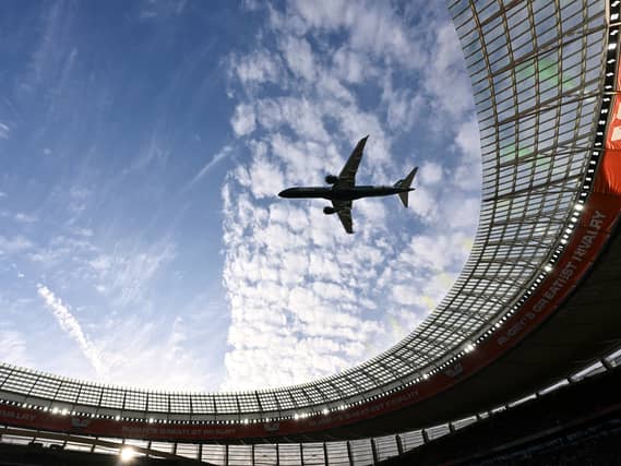 A jet flies over a stadium