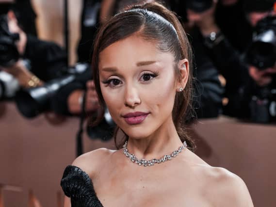 Ariana Grande wearing an off the shoulder black gown with her hair in a ponytail