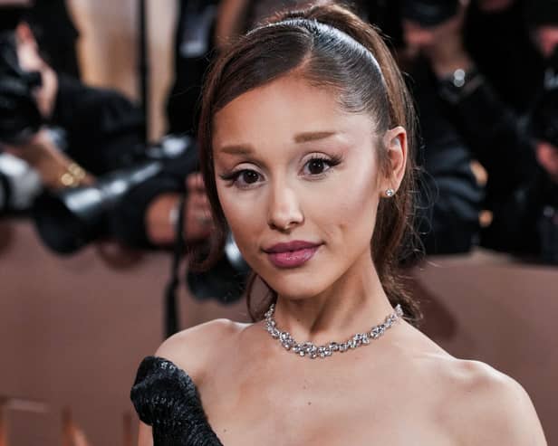 Ariana Grande wearing an off the shoulder black gown with her hair in a ponytail
