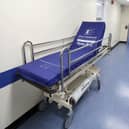 An empty hospital bed in a corridor