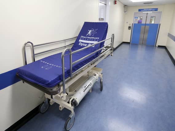 An empty hospital bed in a corridor