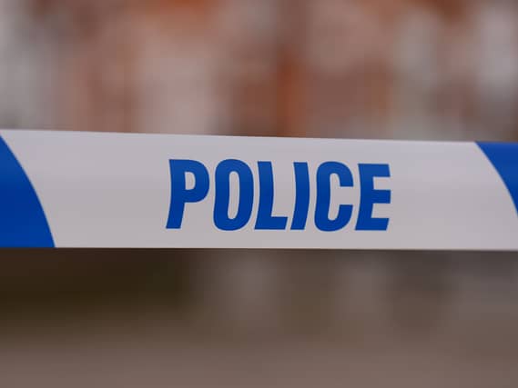 Police tape stretched over a road