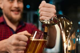 Man pulling a pint behind a bar