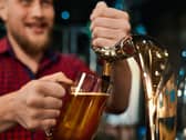 Man pulling a pint behind a bar