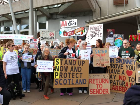 Protesters against data centres holding banners and placards, outside the Scottish Parliament