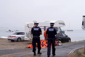 Police officers walk past a pile of discarded life jackets at Eastney Point, near Eastney Beach, Portsmouth