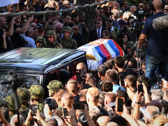 Coffin draped in Serbian flag makes its way through crowd