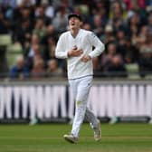 Theo Wylie gets the giggles after taking a catch as a substitute fielder to dismiss Shan Masood