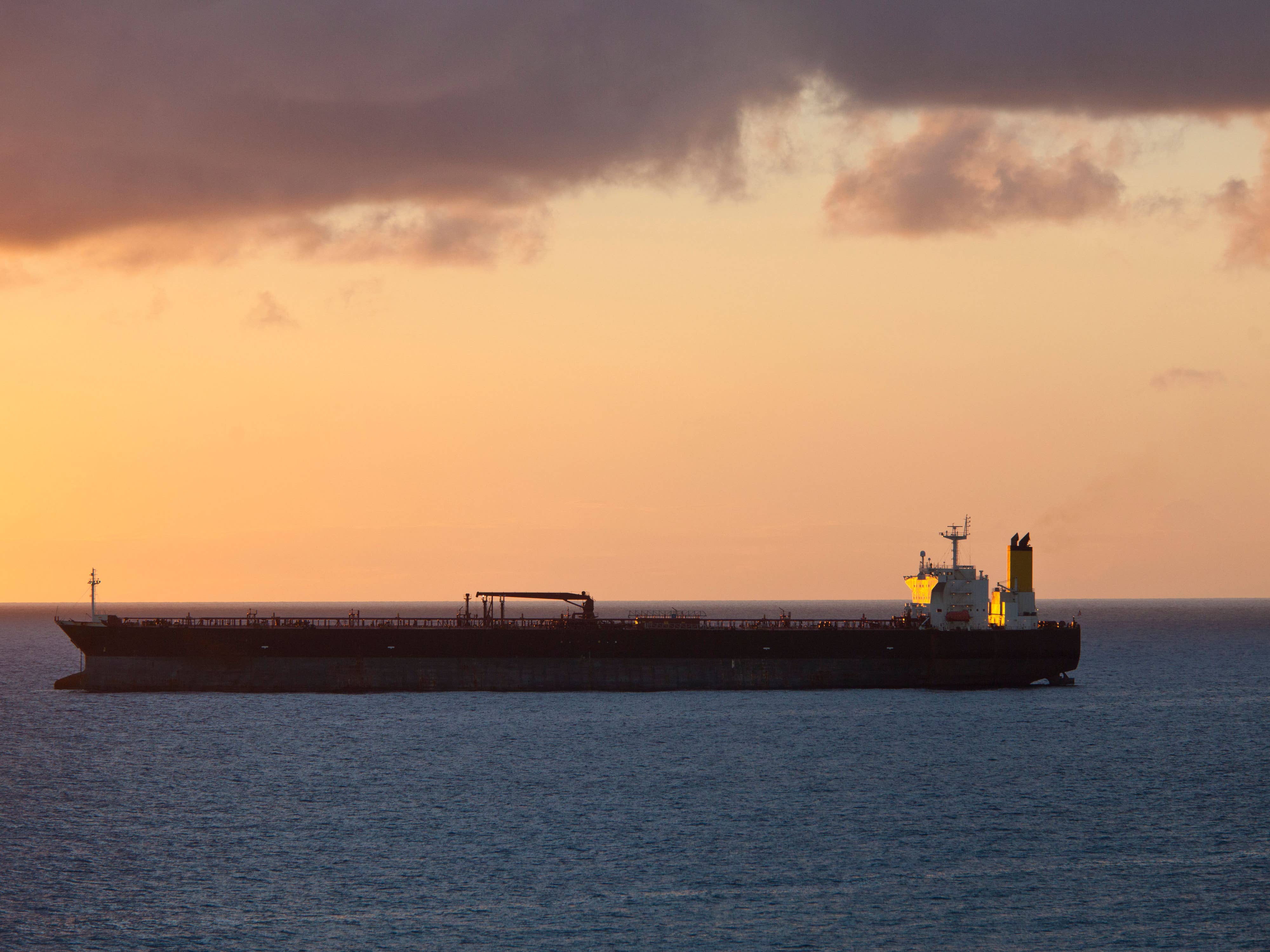 An oil tanker at sea at sunset