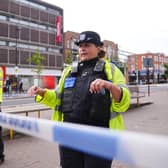 A police officer stands at a crime scene cordon