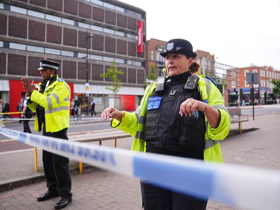 A police officer stands at a crime scene cordon