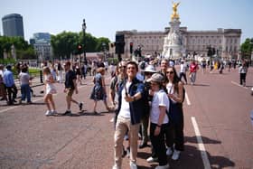 Tourists posing for a selfie in front of Buckingham Palace
