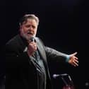 Russell Crowe on stage singing into a microphone
