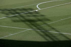 The shadow of a floodlight on the pitch
