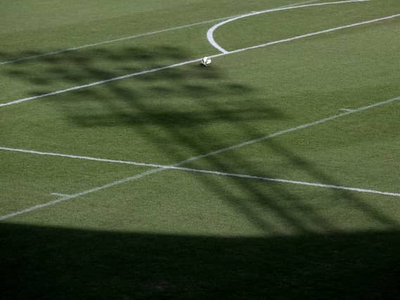 The shadow of a floodlight on the pitch